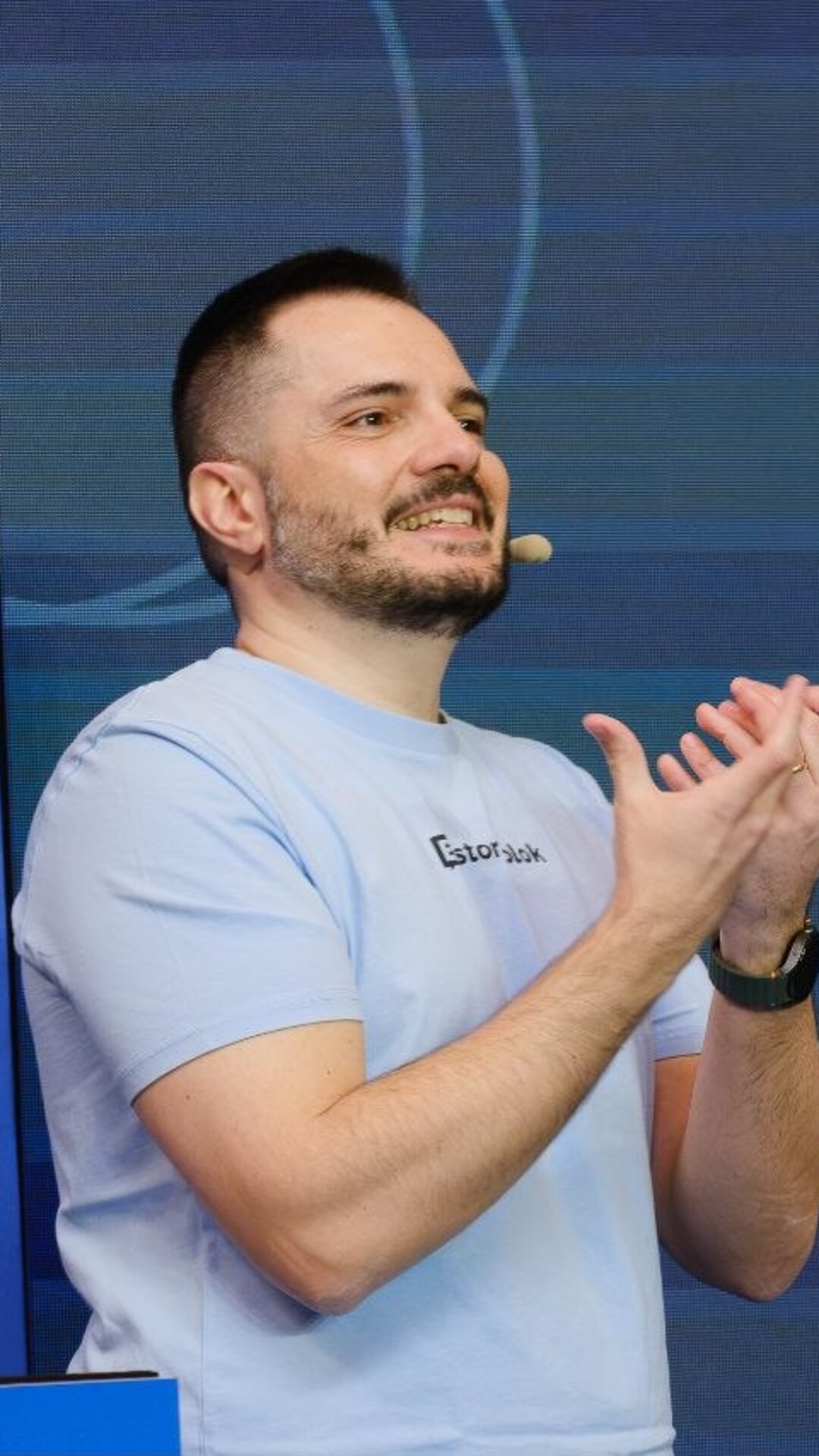 On stage at Codemotion Roma, gesturing mid-explanation in a light blue shirt.